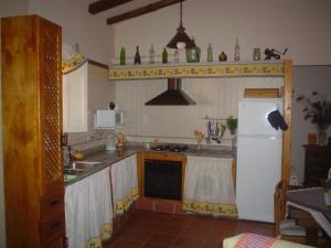 a kitchen with a white refrigerator and a sink at Can Bicicleta de Dalt in Olesa de Bonesvalls