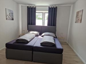 uma cama com duas almofadas num quarto em Nordunterkunft em Neumünster