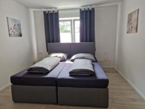 a bed with two pillows on it in a room at Nordunterkunft in Neumünster