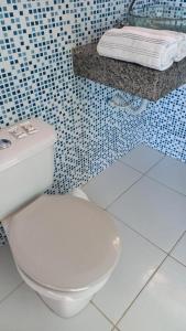 a bathroom with a white toilet and a blue tiled wall at Varandas Lagoa Azul in Araruama