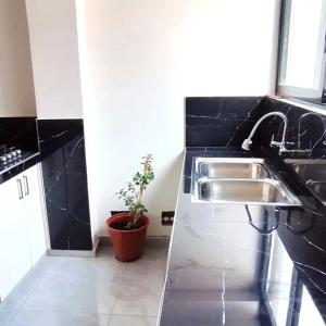 a kitchen with a stainless steel sink and black counters at Departamento privado cerca a la plaza in Pisac