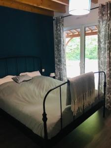 Bett in einem Zimmer mit einem Fenster und einem Bettröckchen-Brustspeck in der Unterkunft Chambre d’hôtes calme - Canal Nantes à Brest in Plessé