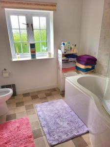 baño con bañera, aseo y ventana en Canalside B and B 