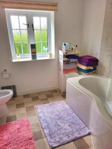 a bathroom with a tub and a toilet and a window at Canalside B and B in Yelvertoft +48 photos