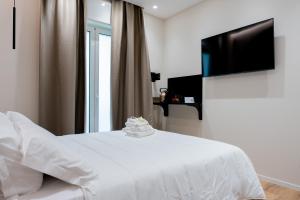 a bedroom with a white bed and a television at CALVANI23 LUXURY HOUSE in Bari