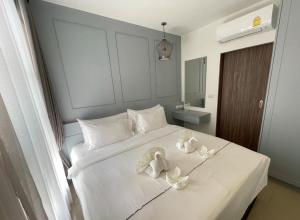 a bedroom with a white bed with towels on it at Modern Condo Palmyrah by Lofty in Ban Lum Fuang +18 photos