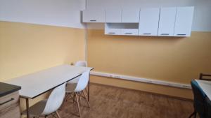 a room with a table and chairs and white cabinets at Privat Prešov in Prešov