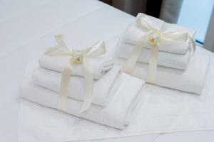 two stacks of towels with white bows on a table at CALVANI23 LUXURY HOUSE in Bari