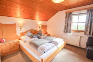 a bedroom with a large bed with a wooden ceiling at Biobauernhof Brandlhof in Ramsau am Dachstein
