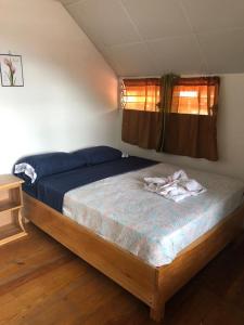 a bedroom with a bed in a room with a window at Hostal Dilu Boquete in Bajo Boquete