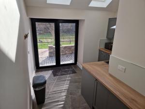 a kitchen with a large window in a room at The Old Pig Sty in Llanellen +6 photos