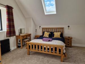 a bedroom with a large wooden bed and a desk at The Old Pig Sty in Llanellen