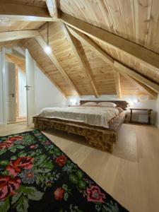 a bedroom with a large bed and a rug at La Tarani in Vatra Dornei