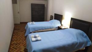 Céntrico en pleno centro Bancario de CBBA في كوتشابامبا: سريرين في غرفة الفندق ذات شراشف زرقاء