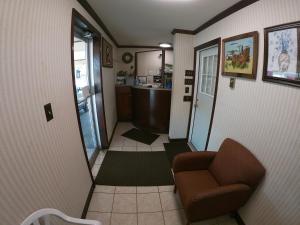 - un couloir avec une chaise et une baignoire dans la chambre dans l'établissement Budget Inn Clearfield PA, à Clearfield