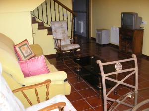 a living room with two chairs and a tv at La Mina de Viñon in Viñón