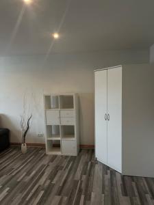 una stanza vuota con un armadietto bianco e pavimenti in legno di Apartmán v rodinném domě a Jaroměř