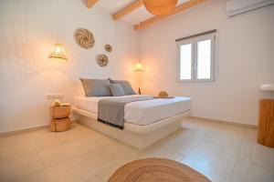 Pregadi Cycladic Suite في ناكسوس تشورا: غرفة نوم بيضاء مع سرير ونافذة