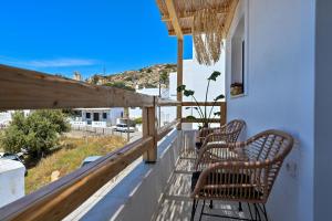 dwa krzesła na balkonie z widokiem na ocean w obiekcie Pregadi Cycladic Suite w mieście Naksos