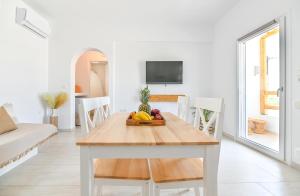 Pregadi Cycladic Suite في ناكسوس تشورا: غرفة معيشة بيضاء مع طاولة عليها فاكهة