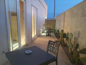 d'une terrasse avec une table, des chaises et un mur. dans l'établissement SeA Beach Home, à Torre Lapillo