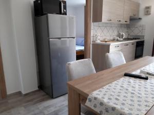 Il comprend une cuisine équipée d'un réfrigérateur et d'une table avec des chaises. dans l'établissement Apartment Karlo, à Kruševo