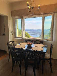 a dining room with a table and chairs and a window at Lorantina House_ Holidays in Corfu in Spartýlas