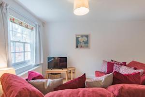 a living room with a red couch and a tv at Vine Cottage by Bloom Stays in Canterbury