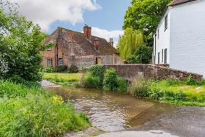 a stream in a village with houses and buildings at Vine Cottage by Bloom Stays in Canterbury