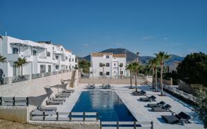 una piscina con tumbonas y edificios en Quattro Suites, en Monemvasia