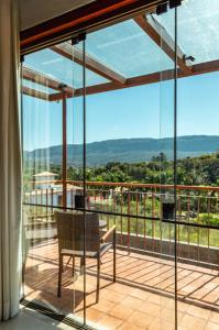 a balcony with a chair and a view of the mountains at Lofts Villa Gratiam in Tiradentes