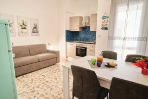 een keuken en een woonkamer met een tafel en een bank bij Conchiglia & Medusa Home Otranto in Otranto