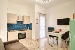 een keuken en een woonkamer met een tafel, een keuken en een eetkamer bij Conchiglia & Medusa Home Otranto in Otranto