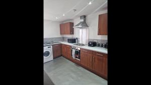 cocina con armarios de madera, lavadora y secadora en Remarkable 2-Bed Apartment in Central Liverpool, en Liverpool