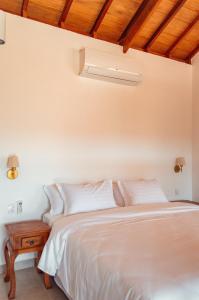 um quarto com uma cama branca e um tecto de madeira em Lofts Villa Gratiam em Tiradentes