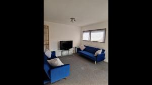 a living room with two blue couches and a tv at Remarkable 2-Bed Apartment in Central Liverpool in Liverpool