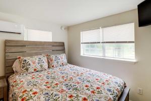 芒廷維尤的住宿－Cozy Studio Less Than 1 Mi to Downtown Mountain View!，一间卧室配有一张带花卉床罩的床和窗户。