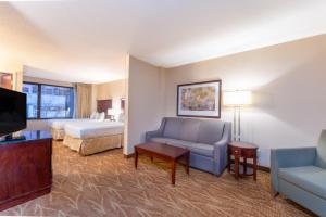 a hotel room with a couch and a bed and a television at Kahler Inn and Suites in Rochester