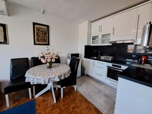 a kitchen with a table with a vase of flowers on it at Apartman Dominik in Zagreb