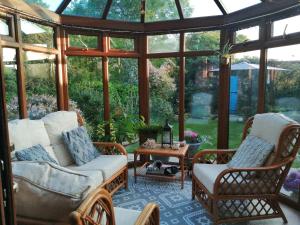 a screened in porch with two chairs and a table at Park House in Leicester