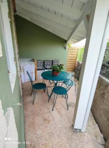 eine Terrasse mit einem Tisch und Stühlen auf einer Veranda in der Unterkunft Maison Mathilde et Simone in Andernos-les-Bains