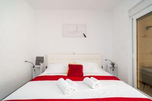 a white bed with two red pillows on it at Dubrovnik Icy Guest House in Dubrovnik