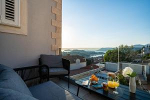 a balcony with a couch and a table with drinks on it at Dubrovnik Icy Guest House in Dubrovnik