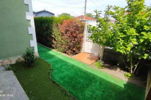 einen Garten mit grünem Rasen vor einem Haus in der Unterkunft Maison Mathilde et Simone in Andernos-les-Bains