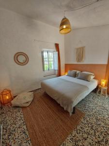 Un dormitorio con una cama grande y una ventana en Finca Serrato, en Colmenar