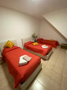 two beds in a room with red sheets at La Fortezza dei Sanniti 