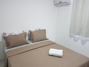 a bed with a roll of paper towels on it at Spazio Jardins do Litoral in Cabedelo