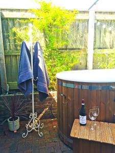 a bath tub and a table with a glass of wine at Historic, traditional & Spacious Wiltshire Cottage in Shrewton