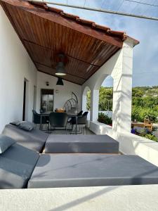 patio z 2 łóżkami, stołem i krzesłami w obiekcie Aegean Endless Summer Villa Pefkos w mieście Pefki