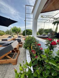 Aegean Endless Summer Villa Pefkos في بيفكي رودس: مجموعة من الكراسي والمظلات على الفناء